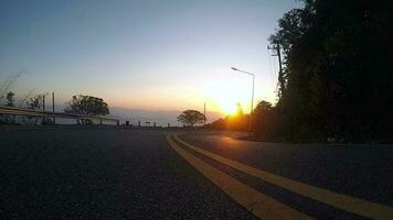 Asphalt road surface with yellow line, Surface grunge rough of asphalt, Dark grey with yellow line on the road and small rock, Texture Background, Top view sunset video