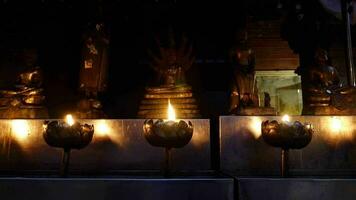 luz uma vela dentro frente do a Buda estátua, velas queimando por aí dentro área do frente Buda estátua video