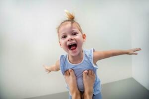 View of feet from mother raised her daughter up on her feet lying on the bed in the bedroom. High quality photo