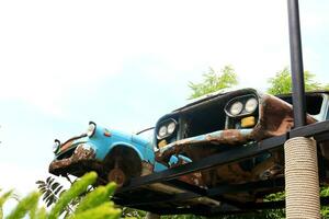 Old and shabby car's body reuse for decoration on stage in outdoor park and bright sky, Thailand. photo