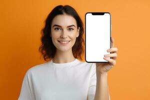 AI generated young woman smiling showing empty with mobile mockup on isolated orange background generative AI photo