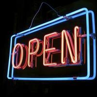 AI generated Neon vibrant OPEN text sign isolated on black photo