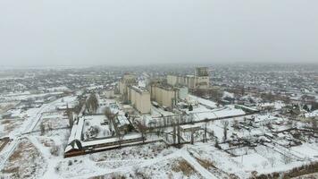 Grain terminal in the winter season. Snow-covered grain elevator in rural areas. A building for drying and storing grain. photo