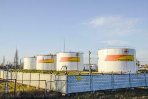 Reservoirs with fuel at the oil depot of Rosneft. Tanks in the light of the setting sun. photo
