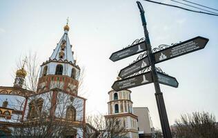 Epiphany Cathedral with a signpost for tell the direction to others attraction landmark in the downtown of Irkutsk, Russia. photo