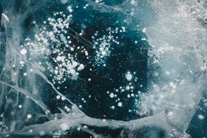 Beautiful cracks surface of the frozen lake of Baikal lake with frost methane bubbles in winter season. Baikal is the largest freshwater lake and the world's deepest lake. photo