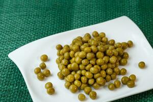 Green peas on a white plate photo