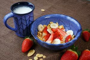 sano desayuno. copos de maíz, Fresco fresas, plátano y Leche foto