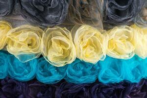 Background of different colors of cloth flowers photo