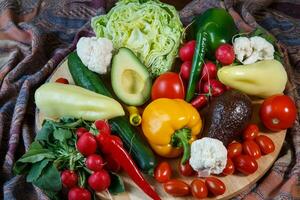 Pile of fresh vegetables and colored fabric photo