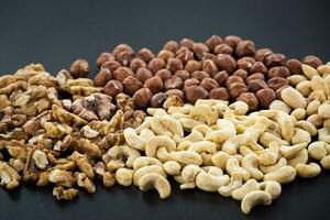 Almonds, cashew, walnuts and hazelnuts on black background photo