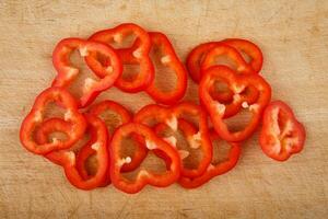 Sliced red peppers on wooden cutting board photo