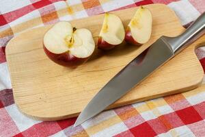 Red apple on cutting board with knife photo