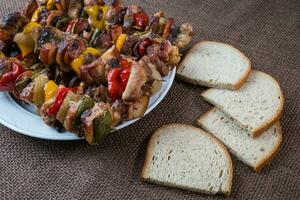 Grilled meat skewers with vegetables and bread photo