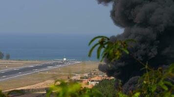 vliegtuig Aan de landingsbaan. rook van een brand in de buurt de luchthaven. video