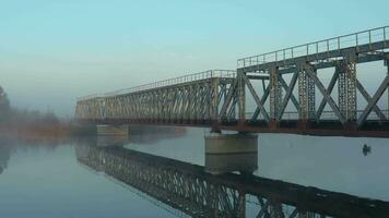 antenne visie van de spoorweg brug over- de rivier- in de mist in de vroeg ochtend- video