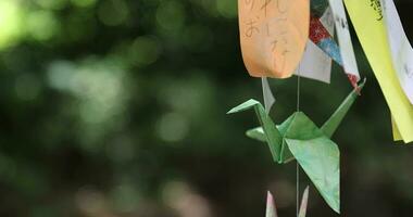 A paper crane swaying in the wind at the traditional street close up handheld video