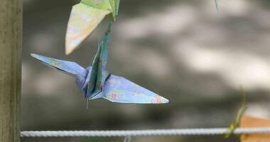 ein Papier Kran schwankend im das Wind beim das traditionell Straße schließen oben Handheld video