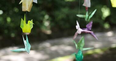 een papier kraan zwaaiend in de wind Bij de traditioneel straat dichtbij omhoog video