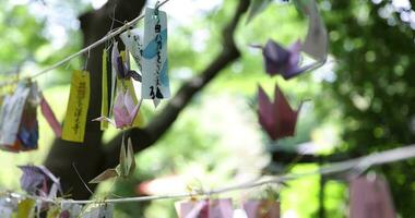 A paper crane swaying in the wind at the traditional street close up video