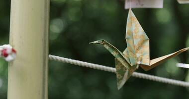 A paper crane swaying in the wind at the traditional street close up handheld video