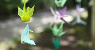 A paper crane swaying in the wind at the traditional street close up video