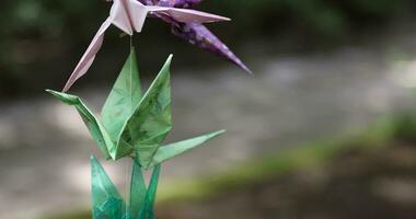 A paper crane swaying in the wind at the traditional street close up handheld video