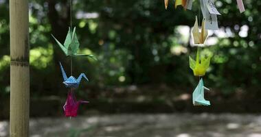 A paper crane swaying in the wind at the traditional street close up video