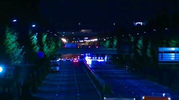 een nacht timelapse van verkeer jam Bij de downtown straat in tokyo telefoto schot kantelen video