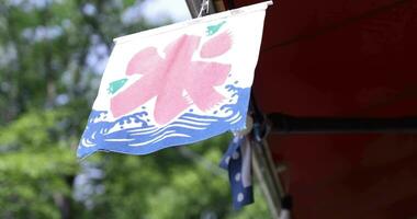 A Japanese shop curtain behind the green tree in summer in Tokyo video