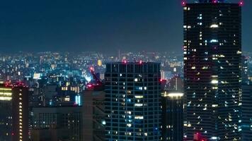 uma noite espaço de tempo do construção luzes dentro Osaka telefoto tiro ampliação video