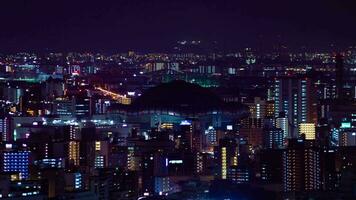 een nacht timelapse van stadsgezicht in de buurt kyocera koepel in Osaka telefoto schot zoom video