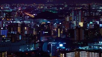 een nacht timelapse van stadsgezicht in de buurt kyocera koepel in Osaka telefoto schot pannen video