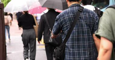 un' lento movimento di a piedi persone a il città strada nel tokyo teleobiettivo tiro video