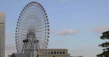 un' rotante Ferris ruota a il urbano città nel Yokohama video