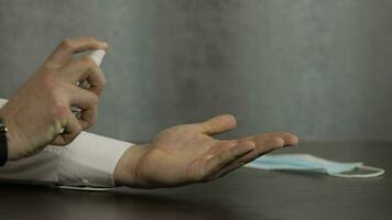 Man using bottle of liquid alcohol spray sanitizer with hands. Coronavirus video