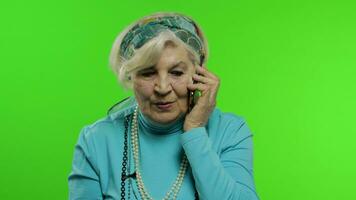 Elderly stylish caucasian grandmother woman talking on mobile phone. Chroma key video