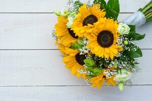 Wedding bouquet of sunflower on a wooden background. Top view with copy space. photo