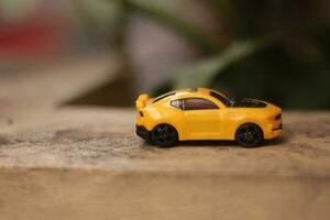 photo of a yellow  toy car with a blurred background.