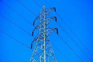 Steel electricity Pylon and High Voltage Power line Electricity transmission photo with blue sky background.