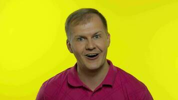 porträtt av caucasian man Framställ i rosa t-shirt. förvånad stilig kille chockad, överraskad, säga Wow video