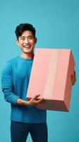 AI generated Joyful man in a blue shirt holding a large pink gift box, exuding happiness and the spirit of giving against a teal background. photo