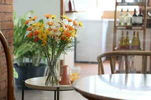 Bouquet of flowers in vase on table in coffee shop photo