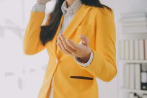 Young smiling business woman using smartphone near computer in office, copy space photo