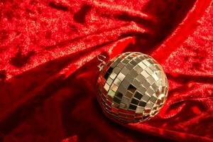 Abstract background made of red velvet fabric with a mirrored New Year's ball. photo