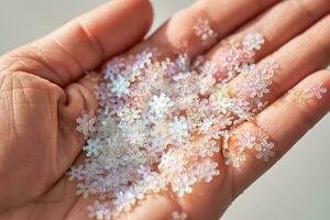 Sequins in the shape of snowflakes on the hand. photo