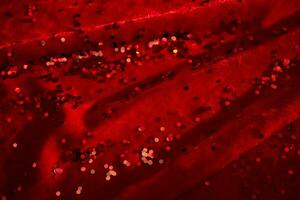 Abstract Christmas background made of red velvet fabric with red sparkles. photo