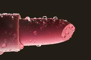 Red lipstick with water drops on a dark background. photo