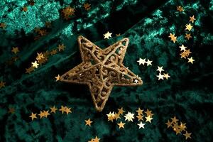 Abstract Christmas background with gold stars on a green velvet background. photo