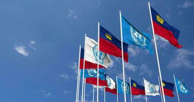 liechtenstein e Unidos nações, un bandeiras acenando juntos dentro a céu, desatado ciclo dentro vento, espaço em esquerda lado para Projeto ou Informação, 3d Renderização video